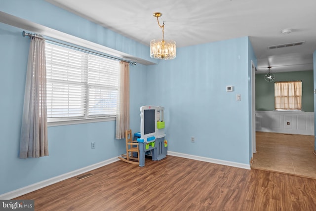 playroom with a notable chandelier and wood-type flooring