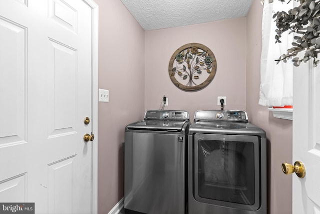 washroom with a textured ceiling and washer and clothes dryer