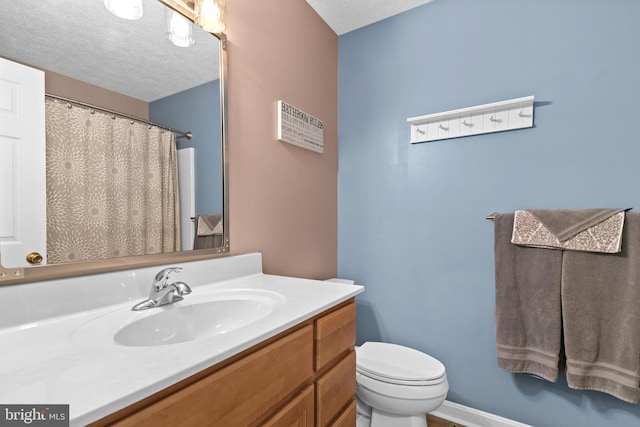 bathroom with vanity, a textured ceiling, and toilet