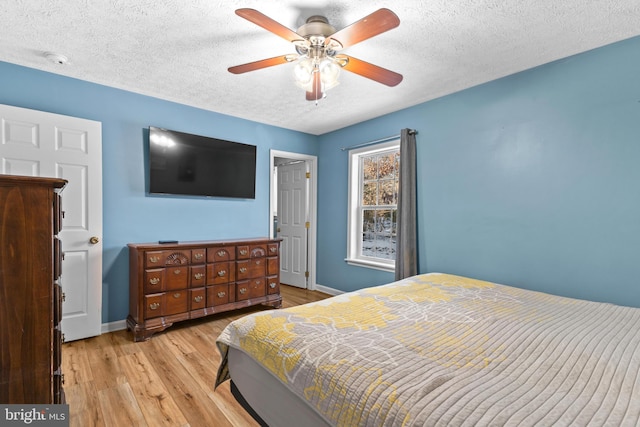 bedroom featuring a textured ceiling, light hardwood / wood-style floors, and ceiling fan