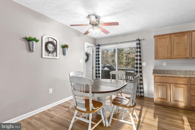 dining space featuring ceiling fan, light hardwood / wood-style floors, and a textured ceiling