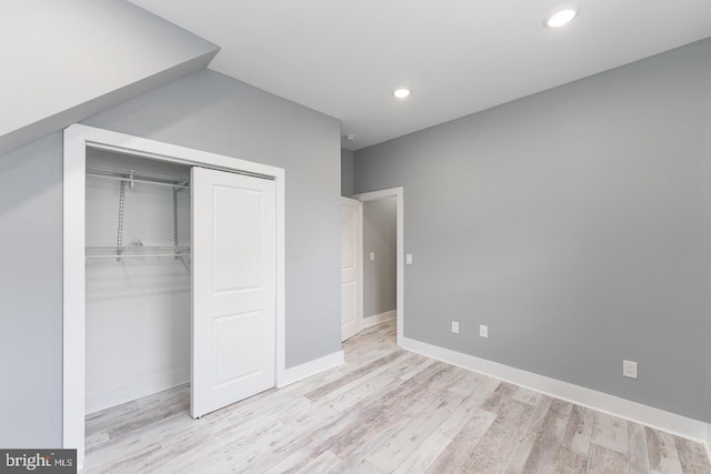 unfurnished bedroom featuring light hardwood / wood-style floors and a closet