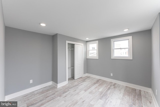 unfurnished bedroom with light hardwood / wood-style flooring and a closet