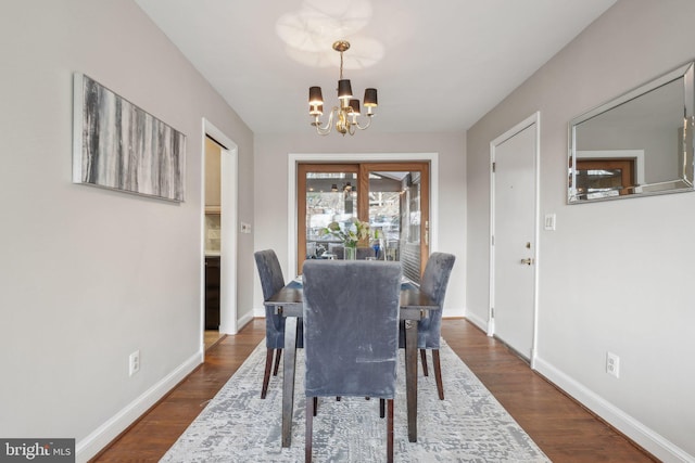 dining space featuring dark hardwood / wood-style flooring and a notable chandelier