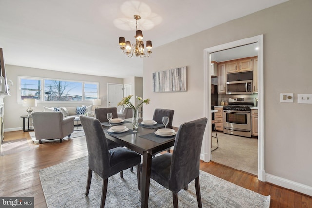 dining area with a notable chandelier and light hardwood / wood-style floors