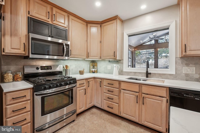 kitchen featuring light brown cabinetry, sink, backsplash, and appliances with stainless steel finishes