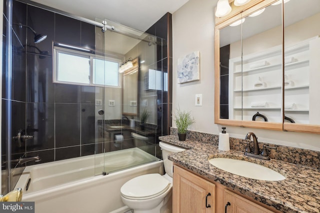 full bathroom featuring toilet, bath / shower combo with glass door, and vanity