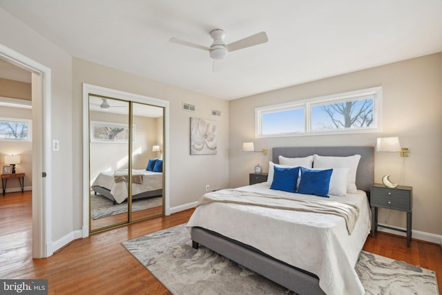 bedroom with ceiling fan, a closet, and hardwood / wood-style floors