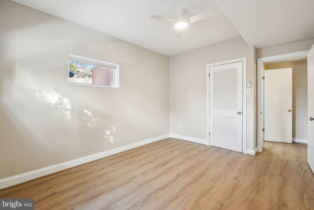 unfurnished bedroom with ceiling fan, light wood-type flooring, and a closet