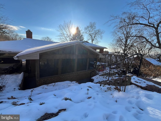 snow covered property with a sunroom