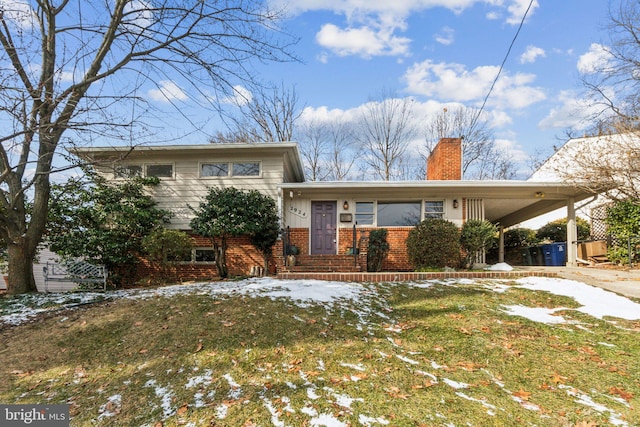 split level home featuring a lawn and a carport