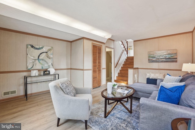 living room featuring wood walls and light hardwood / wood-style flooring