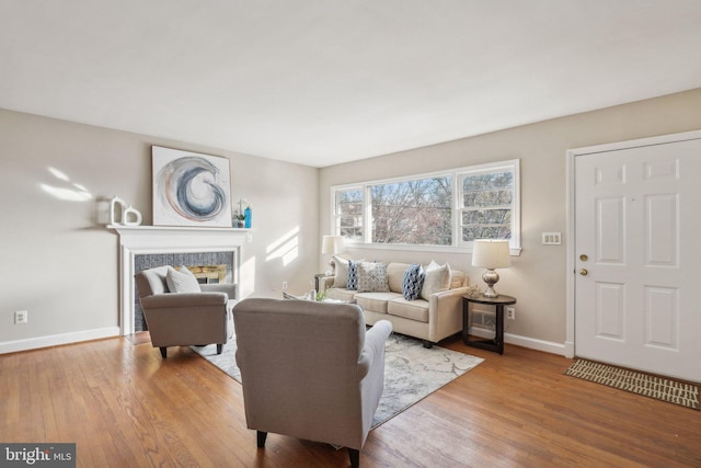 living room with light hardwood / wood-style flooring and a tiled fireplace