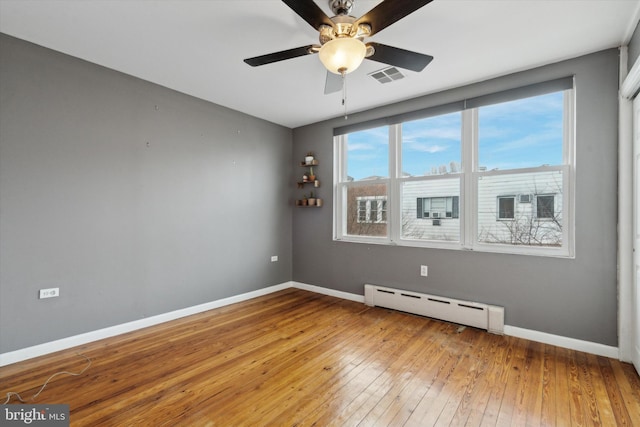 spare room with wood-type flooring, ceiling fan, and baseboard heating