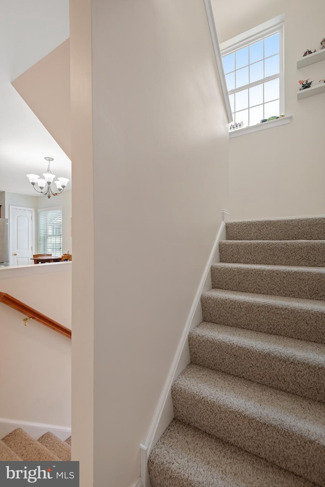 staircase with a chandelier