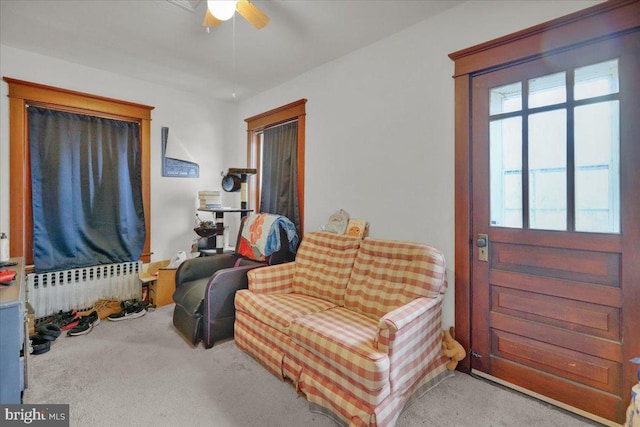 sitting room featuring carpet flooring, ceiling fan, and radiator heating unit