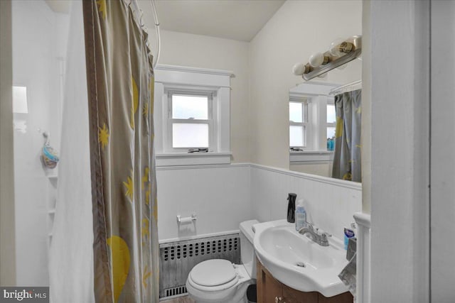 bathroom with vanity, toilet, and radiator