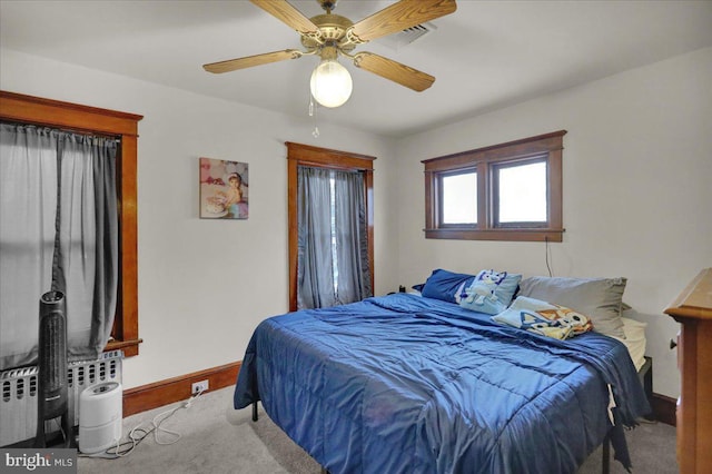 carpeted bedroom with radiator and ceiling fan