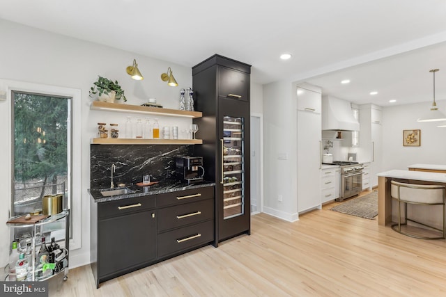 bar featuring white cabinetry, double oven range, backsplash, custom exhaust hood, and light wood-type flooring