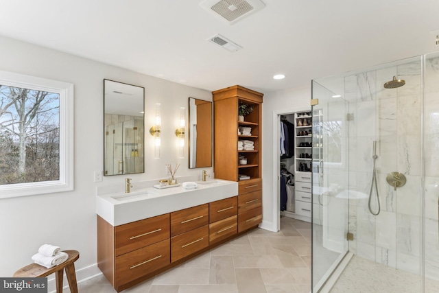 bathroom featuring a shower with door and vanity