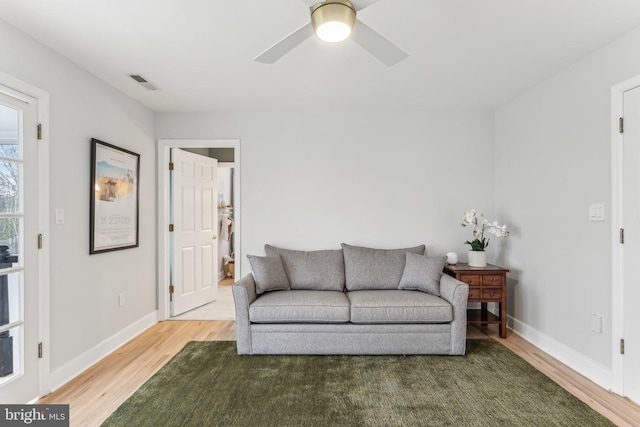 living room with a wealth of natural light, hardwood / wood-style floors, and ceiling fan