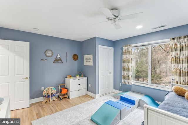 bedroom featuring ceiling fan, multiple windows, and light wood-type flooring