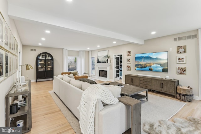 living room with beam ceiling and light wood-type flooring