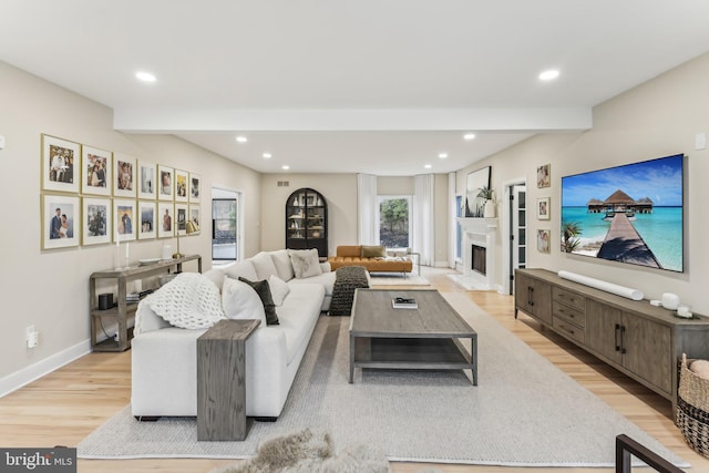 living room featuring beam ceiling and light wood-type flooring