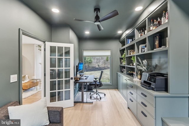 office featuring french doors, built in shelves, ceiling fan, and light hardwood / wood-style flooring