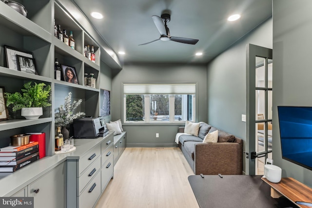 sitting room with ceiling fan and light wood-type flooring