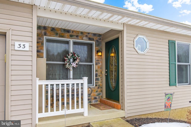 view of exterior entry featuring covered porch