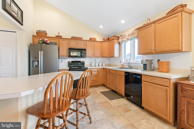 kitchen with sink, tasteful backsplash, vaulted ceiling, and black appliances