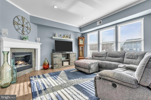 living room with crown molding, a fireplace, and light hardwood / wood-style floors