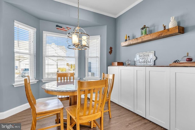 dining space featuring light hardwood / wood-style flooring, a notable chandelier, and crown molding