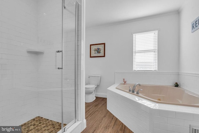 bathroom featuring plus walk in shower, hardwood / wood-style flooring, and toilet