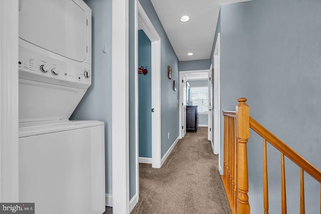 laundry area featuring stacked washer and dryer and carpet