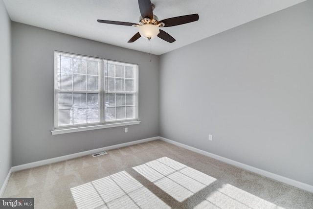 carpeted spare room with ceiling fan