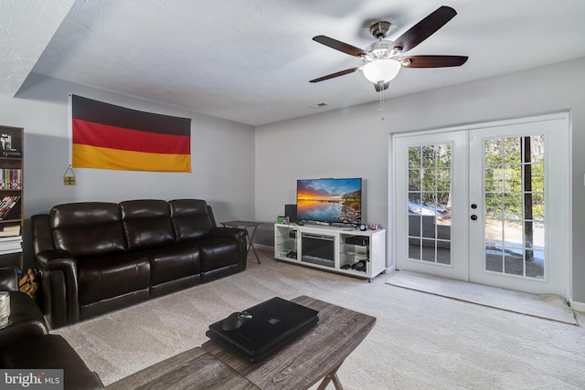 living room featuring carpet, ceiling fan, a textured ceiling, and french doors