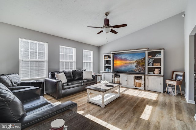 living room with hardwood / wood-style floors, ceiling fan, a textured ceiling, and vaulted ceiling