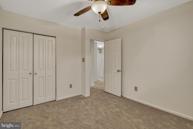 unfurnished bedroom with light carpet, a closet, and ceiling fan