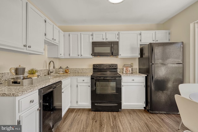 kitchen featuring black appliances, light hardwood / wood-style flooring, white cabinets, and sink