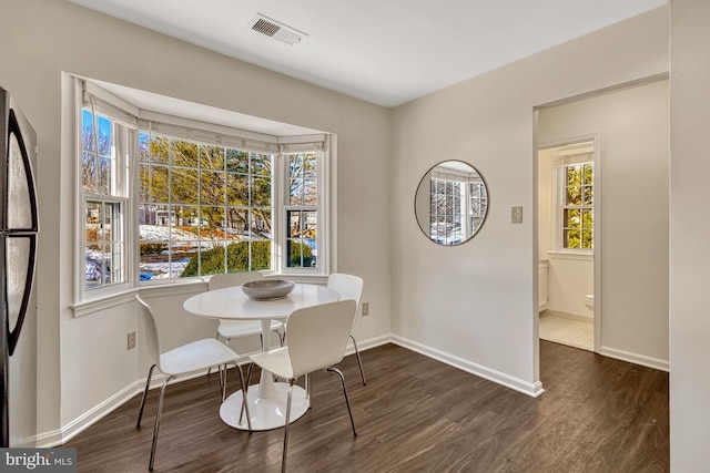 dining room featuring dark hardwood / wood-style flooring and a healthy amount of sunlight