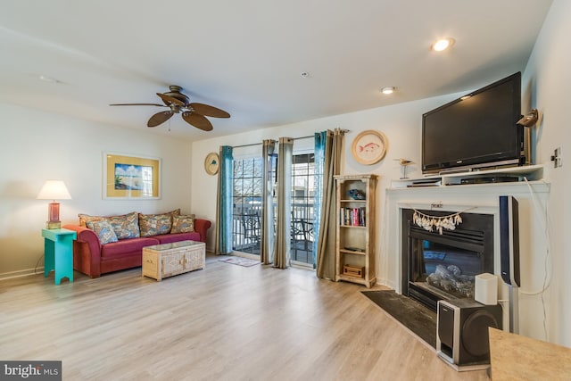 sitting room with ceiling fan and light wood-type flooring