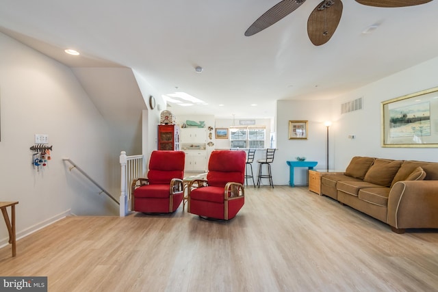 living room featuring light hardwood / wood-style floors and ceiling fan