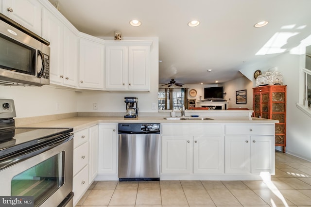 kitchen featuring stainless steel appliances, kitchen peninsula, ceiling fan, white cabinets, and sink