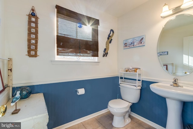 bathroom featuring toilet, tile patterned flooring, and sink