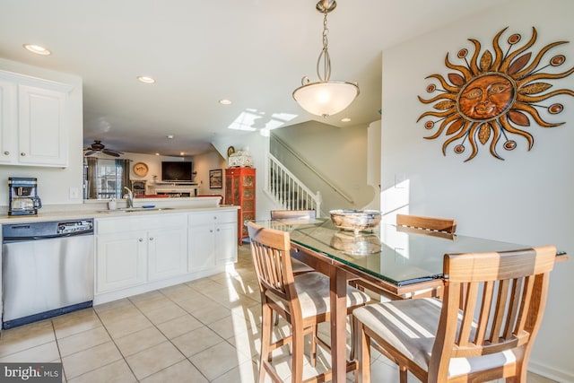 kitchen with kitchen peninsula, dishwasher, light tile patterned floors, white cabinetry, and ceiling fan