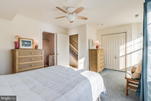 carpeted bedroom with ensuite bathroom, a closet, and ceiling fan