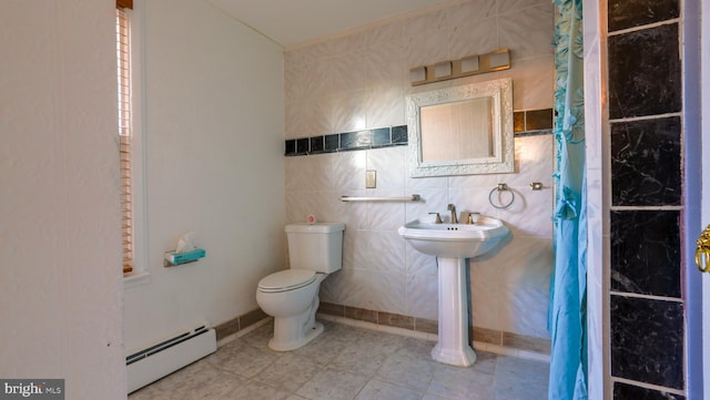 bathroom featuring baseboard heating, toilet, tile patterned floors, tile walls, and sink