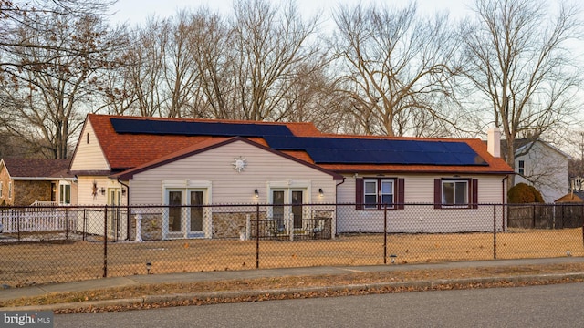 view of front of property featuring french doors and solar panels